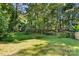 View of the serene backyard featuring a lush green landscape and mature trees at 6515 Santa Cruz Trl, Charlotte, NC 28227
