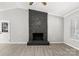 Bright living room features a ceiling fan, new floors and a stone fireplace at 6515 Santa Cruz Trl, Charlotte, NC 28227