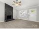 Bright living room features a ceiling fan, new floors and a stone fireplace at 6515 Santa Cruz Trl, Charlotte, NC 28227
