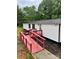This well-maintained mobile home has a metal roof, a ramp, and a small porch painted a vibrant red at 6517 Helens Way, Denver, NC 28037