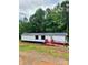 Charming mobile home features a metal roof, white siding, and a red-painted ramp and porch at 6517 Helens Way, Denver, NC 28037