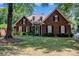Charming brick home with manicured lawn, black shutters, and lush landscaping exudes curb appeal at 7014 Walton Heath Ln, Charlotte, NC 28277