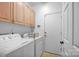 Laundry room featuring a washer, dryer, and upper cabinets at 7014 Walton Heath Ln, Charlotte, NC 28277