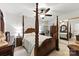Bedroom with a four-poster bed, ceiling fan, and mirror closet doors at 7014 Walton Heath Ln, Charlotte, NC 28277