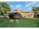 A backyard with a brick house, wooden deck, chimney, and air conditioning units surrounded by green lawn at 753 Briarfield Rd, Rock Hill, SC 29730