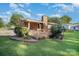 Backyard of a brick house with a wooden porch and chimney, along with landscaped flower beds at 753 Briarfield Rd, Rock Hill, SC 29730