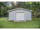 Exterior of a detached garage with a white door and light gray siding, surrounded by a green lawn and trees at 753 Briarfield Rd, Rock Hill, SC 29730