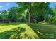 Spacious backyard with lush green grass and mature trees offering shade at 8000 Pelorus Ln, Charlotte, NC 28269