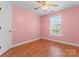 Bedroom with ceiling fan, window with blinds, and wood-look flooring at 8000 Pelorus Ln, Charlotte, NC 28269
