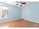 Bedroom with light blue walls, a ceiling fan and hardwood floors offers a cool atmosphere at 8000 Pelorus Ln, Charlotte, NC 28269