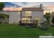 Backyard view of home with deck and well-maintained lawn at sunset at 8000 Pelorus Ln, Charlotte, NC 28269