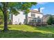 Backyard view of home with deck and well-maintained lawn at 8000 Pelorus Ln, Charlotte, NC 28269
