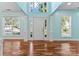 Bright foyer with hardwood floors, white trim, and transom window over the front door at 8000 Pelorus Ln, Charlotte, NC 28269