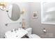 Charming powder room features pedestal sink, decorative mirror and modern lighting at 804 Creek Bluff Rd, Rock Hill, SC 29732