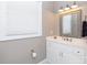 Bright bathroom with a white vanity, framed mirror, window with blinds and neutral colored walls at 804 Creek Bluff Rd, Rock Hill, SC 29732