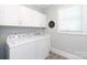 Bright laundry room featuring a Whirlpool washer and dryer, patterned tile floors and ample overhead storage at 804 Creek Bluff Rd, Rock Hill, SC 29732