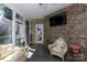 Cozy sunroom with stone walls, comfortable wicker seating, a ceiling fan, and screened windows at 804 Creek Bluff Rd, Rock Hill, SC 29732