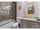 Well-lit bathroom featuring a shower-tub combo with tiled walls, granite countertop vanity, and neutral walls at 9110 Woodhall Lake Dr, Waxhaw, NC 28173