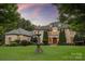 A stately brick home has a manicured lawn and circular driveway, along with a decorative water fountain at 9110 Woodhall Lake Dr, Waxhaw, NC 28173