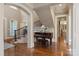 Grand foyer with hardwood floors, staircase, and a piano, showcasing an open floor plan at 9110 Woodhall Lake Dr, Waxhaw, NC 28173