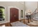 Elegant foyer with hardwood floors, a curved staircase, and a view into the formal dining room at 9110 Woodhall Lake Dr, Waxhaw, NC 28173