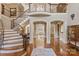 Expansive foyer with a curved staircase, iron railings, and access to multiple living spaces at 9110 Woodhall Lake Dr, Waxhaw, NC 28173
