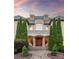 Grand entrance featuring a covered porch with columns, double doors, and manicured greenery at 9110 Woodhall Lake Dr, Waxhaw, NC 28173