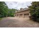 A three car attached garage is made of brick with a large parking area made of brick pavers at 9110 Woodhall Lake Dr, Waxhaw, NC 28173