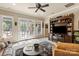 Bright living room with a large entertainment center, hardwood floors, many windows, and doors to the backyard pool at 9110 Woodhall Lake Dr, Waxhaw, NC 28173