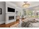 Primary bedroom with fireplace, wood floors, windows, and ensuite bathroom offers private retreat at 9110 Woodhall Lake Dr, Waxhaw, NC 28173