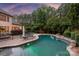 Backyard pool area surrounded by beautiful landscaping, patio space, and comfortable seating at 9110 Woodhall Lake Dr, Waxhaw, NC 28173
