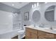 Bright bathroom featuring a double vanity, a shower-tub combo with glass doors, and neutral wall color at 10104 Treetop Ln, Cornelius, NC 28031