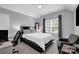 Modern bedroom with a sleek black platform bed, plush gray carpeting, and a bright window at 10104 Treetop Ln, Cornelius, NC 28031