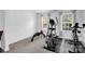This carpeted exercise room includes an elliptical and bench with dumbbells for a complete workout at 10104 Treetop Ln, Cornelius, NC 28031