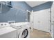 Functional laundry room includes a washer, dryer, utility sink, and storage shelves at 10104 Treetop Ln, Cornelius, NC 28031