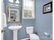 This powder room features a pedestal sink, toilet, framed mirror and paint in a complementary color at 10104 Treetop Ln, Cornelius, NC 28031