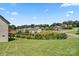 Expansive backyard with a grassy lawn, neighborhood views, and mature trees under a clear blue sky at 1033 12Th Avenue Nw Dr, Hickory, NC 28601