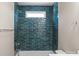 A stylish bathroom with teal tiling, a shower-tub combo, and a window for natural light at 1033 12Th Avenue Nw Dr, Hickory, NC 28601