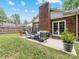 A cozy back patio featuring outdoor seating, a grill, and a brick chimney at 1115 Berry Ridge Rd, Charlotte, NC 28270