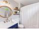 Stylish bathroom with modern fixtures, rounded mirror, and shelving at 1115 Berry Ridge Rd, Charlotte, NC 28270