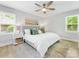 Sunlit bedroom with large windows, hardwood floors, ceiling fan, and a comfortable bed at 1115 Berry Ridge Rd, Charlotte, NC 28270
