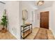 Warm foyer featuring wood-look floors, console table with decor, and a classic wooden front door at 1115 Berry Ridge Rd, Charlotte, NC 28270
