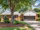 Brick exterior of a well-kept home featuring a two-car garage, yellow door, and manicured landscaping at 1115 Berry Ridge Rd, Charlotte, NC 28270