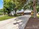 View of the front of the home with an extended driveway and mature trees in the front yard at 1115 Berry Ridge Rd, Charlotte, NC 28270