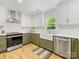 Updated kitchen with white upper cabinets, sage lower cabinets, and marble countertops at 1115 Berry Ridge Rd, Charlotte, NC 28270