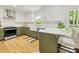 Bright kitchen featuring white and sage cabinets, marble countertops, and stainless steel appliances at 1115 Berry Ridge Rd, Charlotte, NC 28270