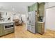Open concept kitchen with green cabinets, stainless steel appliances, and access to the dining and living rooms at 1115 Berry Ridge Rd, Charlotte, NC 28270