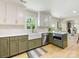 Tastefully designed kitchen with green cabinets, modern appliances, and a view into the dining area at 1115 Berry Ridge Rd, Charlotte, NC 28270