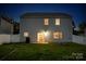 Exterior view of a two story house with a backyard at dusk featuring a fire pit at 116 Kingsway Dr, Mooresville, NC 28115