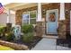 Charming front porch featuring stone pillars, rocking chairs and vibrant landscaping at 116 Kingsway Dr, Mooresville, NC 28115